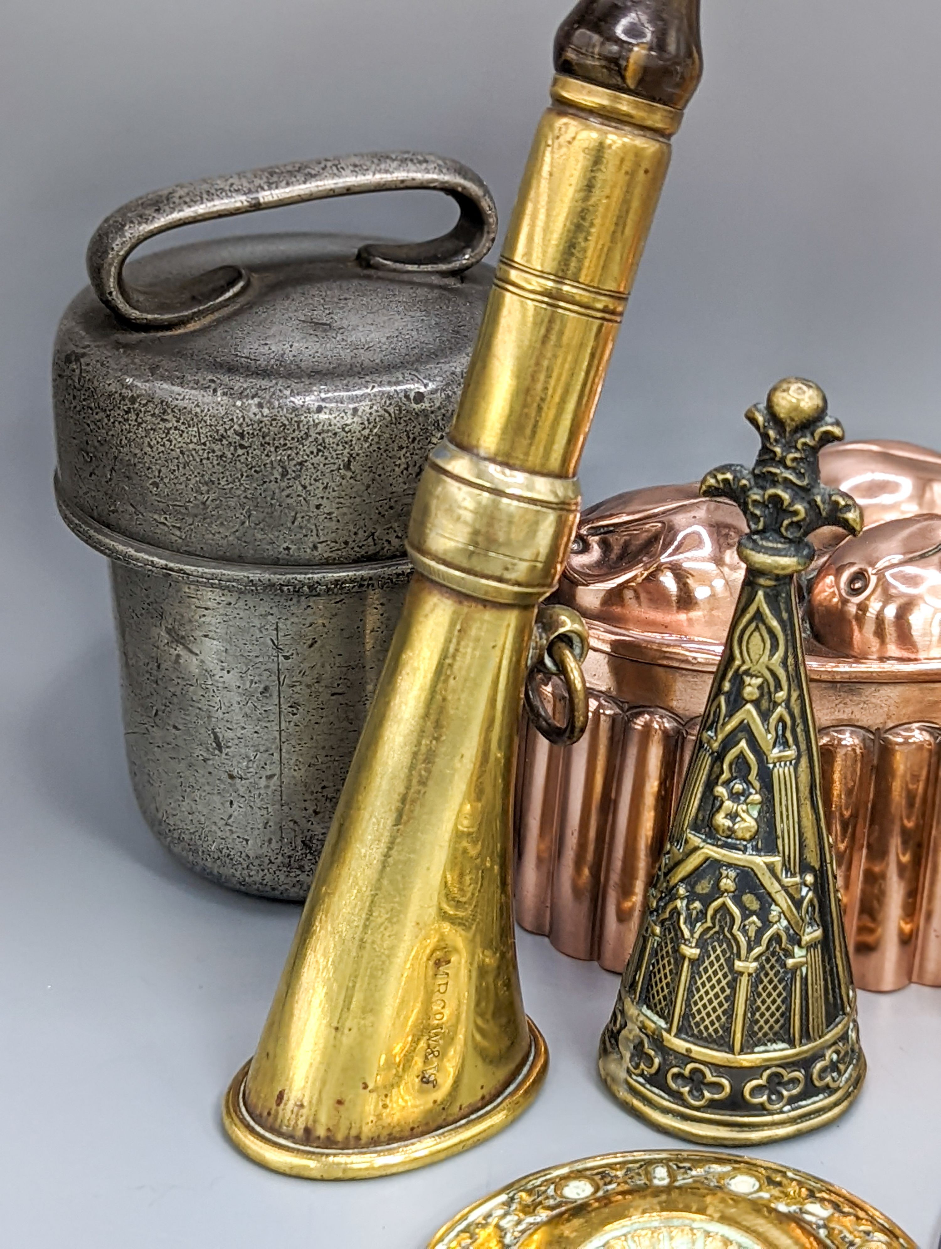 A leather cider costrel, miniature metalware including horn and two jelly moulds, brass horn, etc. and three martingales